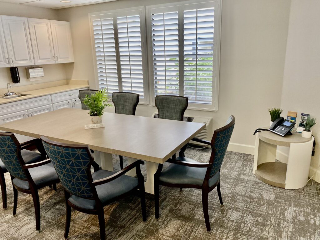 Private meeting or consultation room at Springwood Court in Florida with a large table and six chairs.